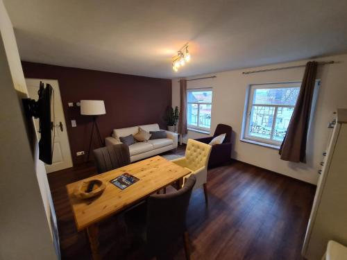 a living room with a table and a couch at Urlaub am Mittelpunkt. Neue Ferienwohung im alten Mehlager in Niederdorla
