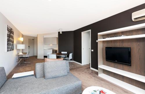 a living room with a couch and a flat screen tv at AAC Apartments - Griffin in Canberra