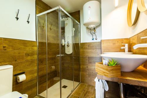 ein Badezimmer mit Glasdusche und Waschbecken in der Unterkunft Coral Friendly Holiday Home in Playa del Ingles