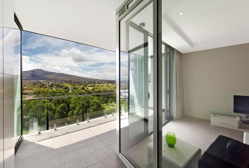 a living room with a glass wall at AAC Apartments - Manhattan in Canberra