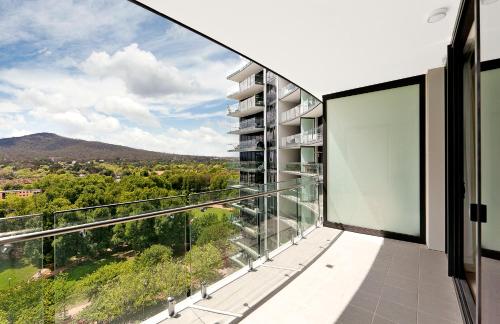 an apartment balcony with a view of the mountains at AAC Apartments - Manhattan in Canberra