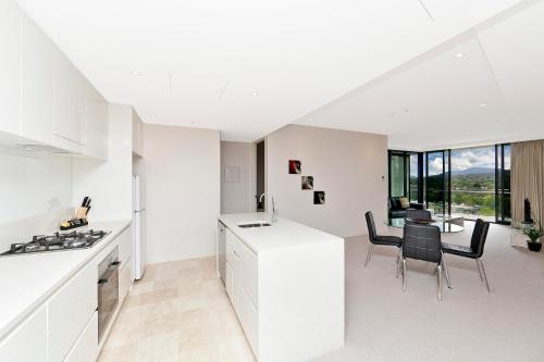 a kitchen and dining room with a table and chairs at AAC Apartments - Manhattan in Canberra