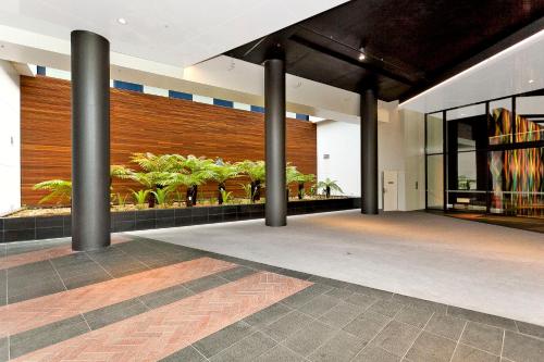 a lobby with columns and plants in a building at AAC Apartments - Manhattan in Canberra