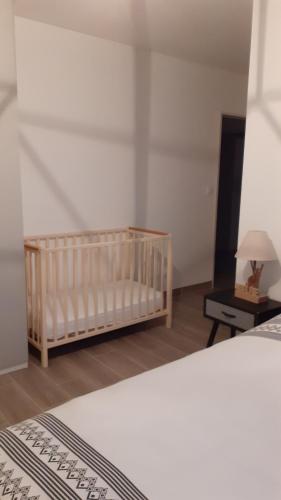 a bedroom with a crib and a table with a lamp at Evadorie in Le Barroux