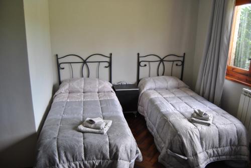 two beds in a room with towels on them at Finca Arroyo del Valle NO HAY PISCINA in San Andrés del Rabanedo