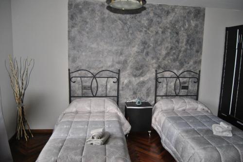 two twin beds in a room with a wall at Finca Arroyo del Valle NO HAY PISCINA in San Andrés del Rabanedo