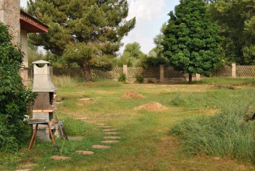 a garden with a bell in the grass at Finca Arroyo del Valle NO HAY PISCINA in San Andrés del Rabanedo