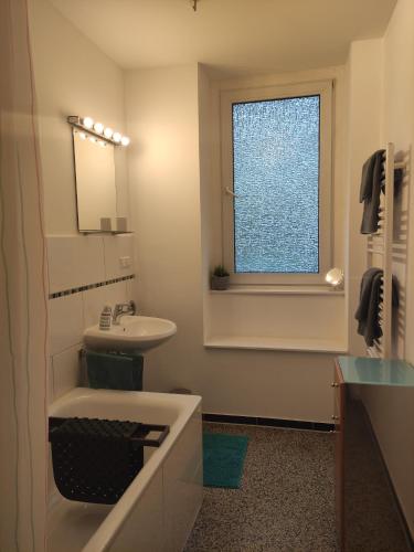 baño con bañera, lavabo y ventana en Apartment Philosophenviertel, en Hannover