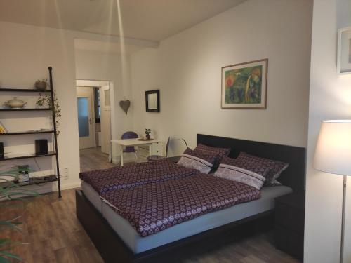 ein Schlafzimmer mit einem Bett, einem Tisch und einer Lampe in der Unterkunft Apartment Philosophenviertel in Hannover