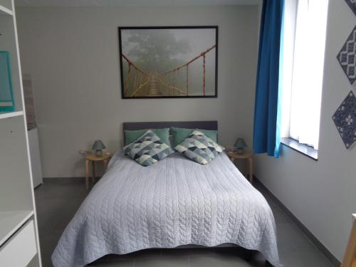 a bedroom with a bed with a bridge picture on the wall at AU PIED DE L'ABBAYE DE LEFFE in Dinant