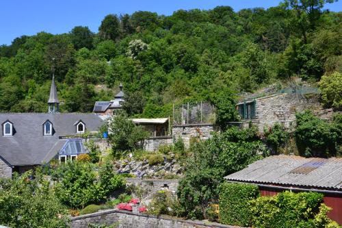 a village with houses and a church on a hill at AU PIED DE L'ABBAYE DE LEFFE in Dinant