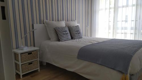 a bedroom with a bed with pillows and a window at Le Galet in Dieppe