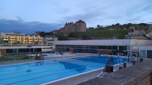 une grande piscine avec un château en arrière-plan dans l'établissement Le Galet, à Dieppe