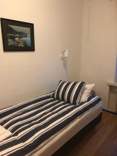 Bett mit gestreiften Kissen in einem Zimmer in der Unterkunft Captain’s Cabin Jakobstad Pietarsaari center in Pietarsaari