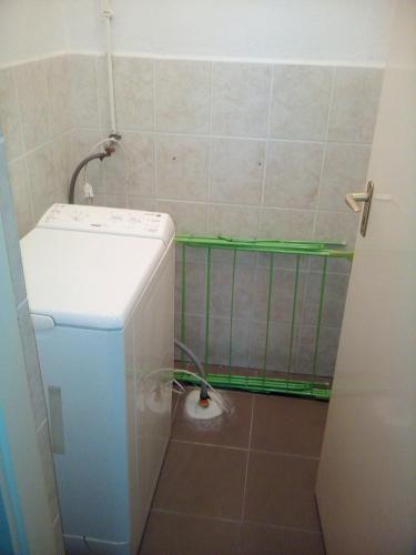 a small bathroom with a washing machine in the corner at Dráva Völgye Vendégház in Zákány