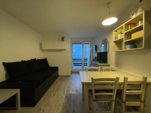 un salon avec un canapé, une table et des chaises dans l'établissement LOuréa studio 4 pers retour skis au pieds, à Les Deux Alpes