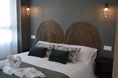 una camera da letto con letto, testiera e cuscini in legno di GRETA PLAYA PANORAMA APARTAMENTO by AlohaMalaga a Málaga
