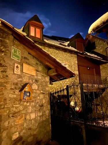 a stone building with a gate and a bird house at Casa Campolé in San Juan de Plan