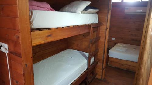 2 łóżka piętrowe w drewnianym domku z: w obiekcie Cabañas Diamante w mieście Gualeguaychú