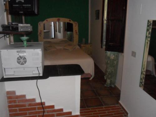 a bedroom with a bed with a microwave and acomputer on a counter at Alla Finestra Sul Parco in Cefalù