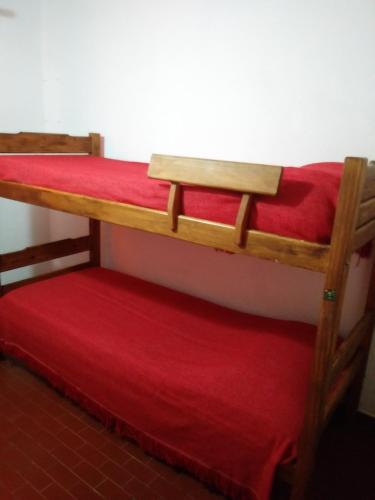 2 literas en una habitación con sábana roja en Duplex en San Bernardo a dos cuadras de la playa en San Bernardo