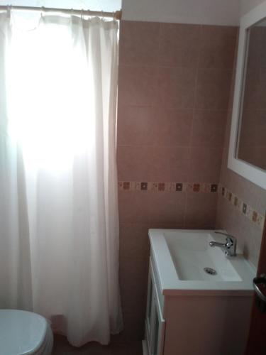 圣贝尔纳多Duplex en San Bernardo a dos cuadras de la playa的浴室设有白色的淋浴帘和水槽
