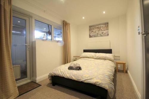 a bedroom with a bed and a window at Pebbles Apartment By Air Premier in Seaford