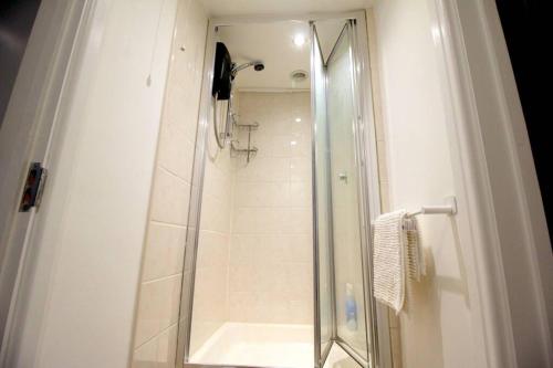 a shower with a glass door in a bathroom at Pebbles Apartment By Air Premier in Seaford