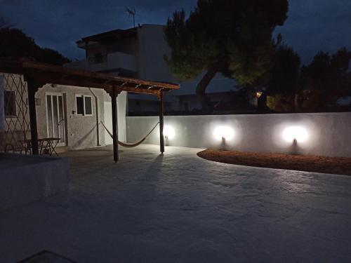 a patio at night with lights on a wall at Artemis Boutique House in Artemida