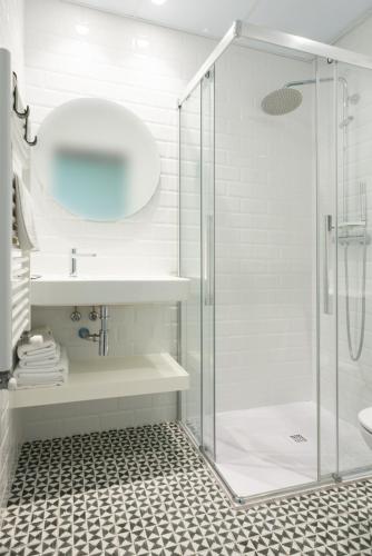 a bathroom with a glass shower and a sink at Carrioza Alojamiento Turístico in Parada del Sil