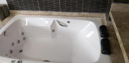 a white bath tub with a faucet in a bathroom at Casa com Piscina e Hidromassagem Montoski in Bombinhas