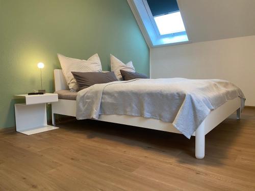 - une chambre avec un grand lit et une lucarne dans l'établissement Helle Dachgeschosswohnung in Bockhorn, LK Friesland, à Bockhorn