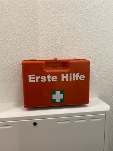 an orange suitcase sitting on top of a dresser at Helle Dachgeschosswohnung in Bockhorn, LK Friesland in Bockhorn