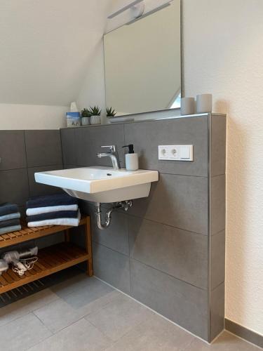 ein Bad mit einem Waschbecken und einem Spiegel in der Unterkunft Helle Dachgeschosswohnung in Bockhorn, LK Friesland in Bockhorn