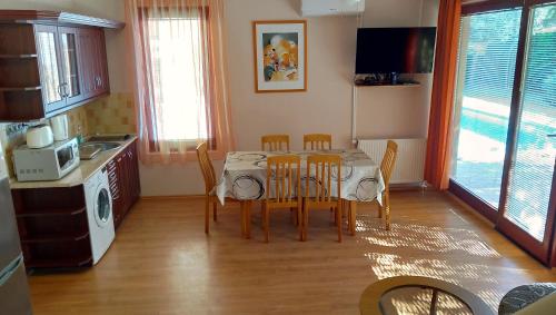 een keuken met een tafel en stoelen bij Jenny apartman Siófok in Siófok