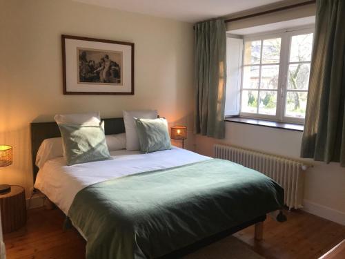 Schlafzimmer mit einem Bett mit grüner Bettwäsche und einem Fenster in der Unterkunft Le Domaine de Camblanes in Camblanes-et-Meynac