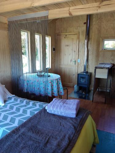 a bedroom with a bed and a table with a stove at Fío Fío Patagonia in Chaitén