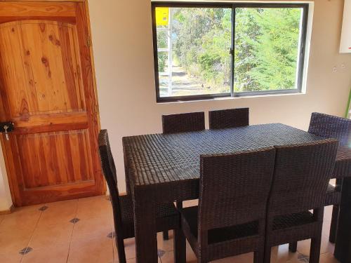 a dining room with a table and chairs and a window at Parcela de 3 hectáreas con orilla de Lago in Las Cabras