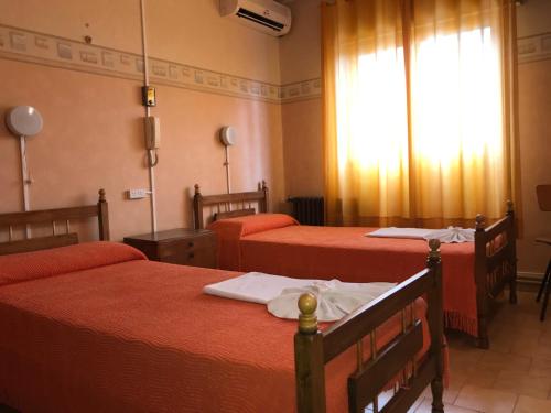 En eller flere senge i et værelse på HOTEL ESCORIAL