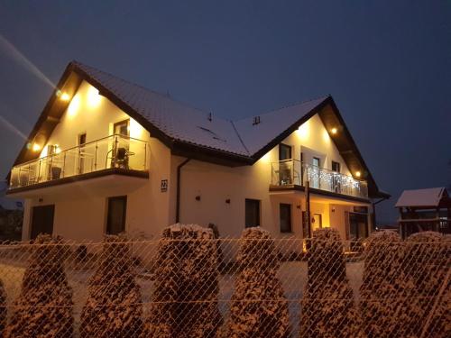 una casa con una valla delante de ella por la noche en Pensjonat Dziki Zakątek, en Grzybowo