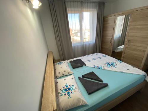 a bedroom with a bed with blue sheets and a window at Apartament Sulina in Sulina