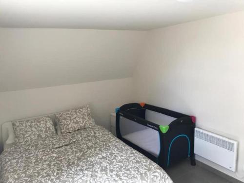 - une chambre avec un lit et un mur blanc dans l'établissement Vakantiehuisje De Panne vlak aan Plopsaland en de zee, à La Panne