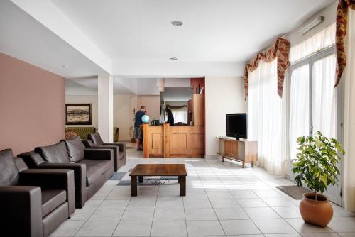 a living room with couches and a tv and a table at Hotel Amado in El Calafate