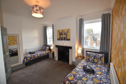 uma sala de estar com 2 camas e uma lareira em Maytree 2 Bed Apartment - STAYSEEKERS em Salisbury