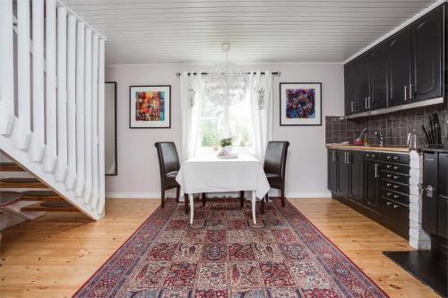 a dining room with a white table and black cabinets at Bergsmansgårdens Gästhus in Asphyttan