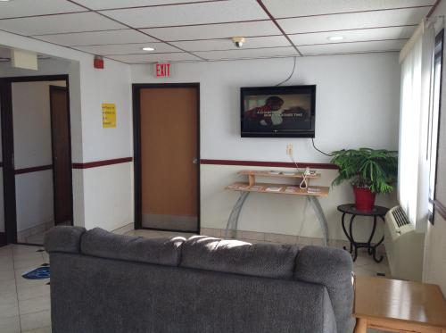 a waiting room with a couch and a exit door at Super 8 by Wyndham Winchester VA in Winchester