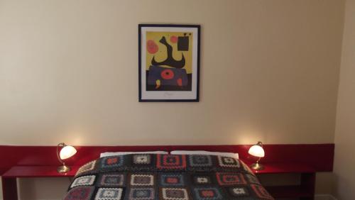 a bedroom with a bed with two lamps and a picture on the wall at Kilcommon Lodge Holiday Hostel in Belmullet