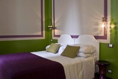 a bedroom with a white bed with green walls at Hotel Colombo Genova in Genova