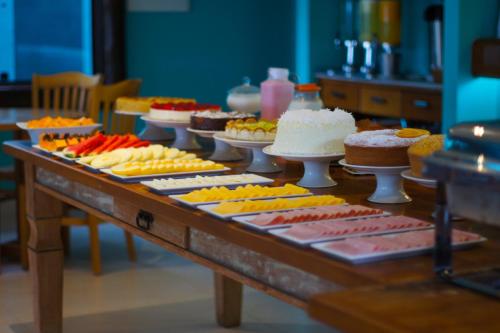a table with many different types of cakes on at Pousada Recreio Da Praia in Abraão