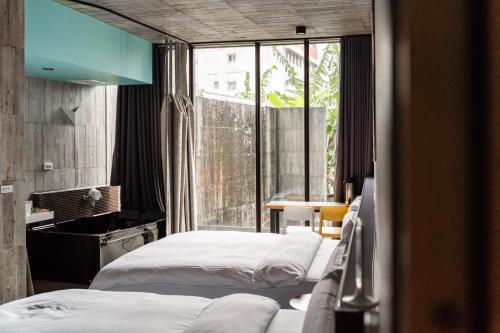 1 dormitorio con 2 camas y ventana grande en YZ SPA House, en Jiaoxi